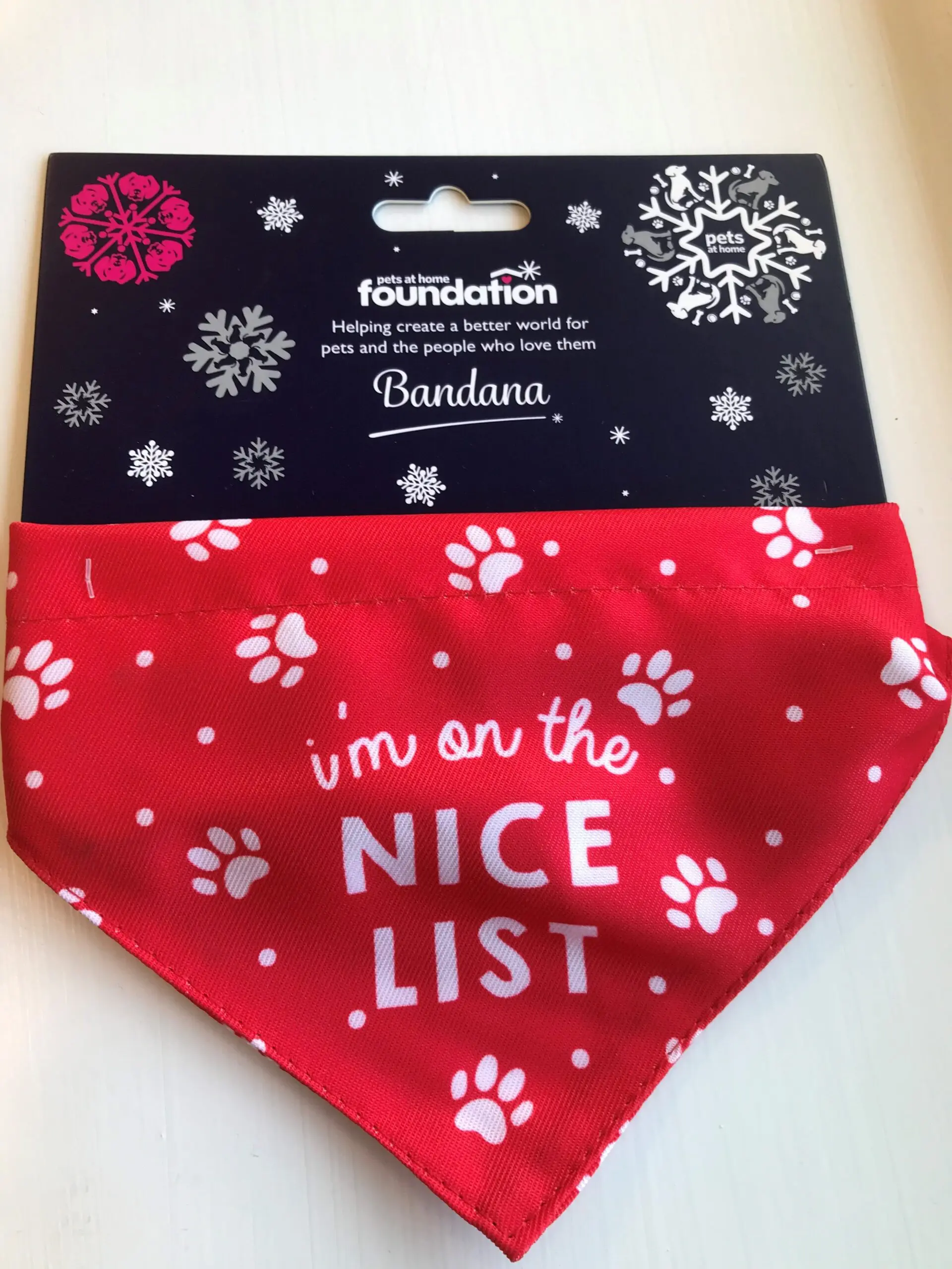 Pets Foundation Santa Paws red bandana with "I'm on the nice list" and white paw prints on the front
