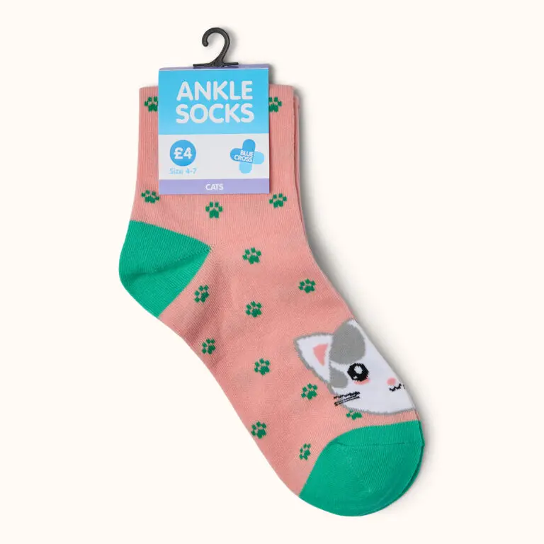 Blue Cross cat-themed pink ankle socks with green paw prints and cat face design, displayed with retail packaging showing size 4-7.