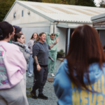 A group of people walking around an animal rescue and rehoming centre.