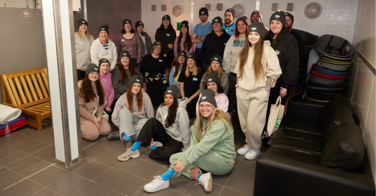 A group of Pets at Home Colleagues at a rescue and rehoming centre for a kennel sleepout, posing for a group photo.