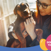 Woman with glasses holding a brown coloured dog